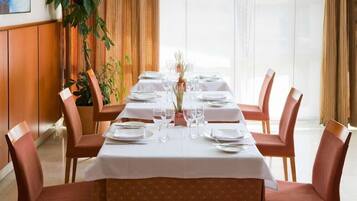 Un comedor con una mesa larga dispuesta para seis personas, rodeada por seis sillas.