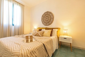 Een netjes ingerichte slaapkamer met een bed, nachtkastje en een decoratie aan de muur.