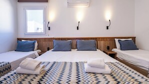 A hotel room with two beds, a window, an air conditioner, and wall-mounted lights. - Costa Viva Bodrum (Bodrum)