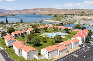A residential area with a swimming pool surrounded by houses with red roofs.