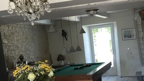 A dining area with a pool table, a chandelier, and a vase of flowers. - Ile de re family house, garden swimming pool, close to the sea on foot. (Sainte-Marie-de-Ré)