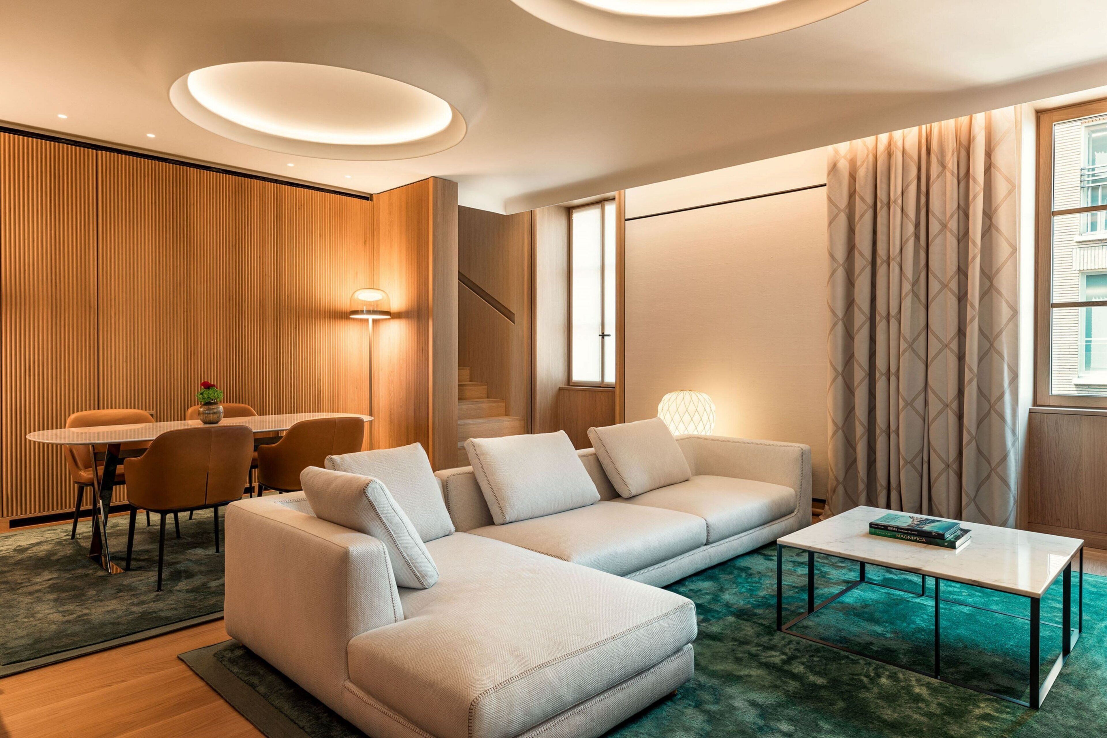 Ein modernes Wohnzimmer mit Sofa, Couchtisch und Essbereich.