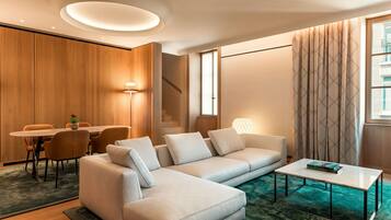 Ein modernes Wohnzimmer mit Sofa, Couchtisch und Essbereich.