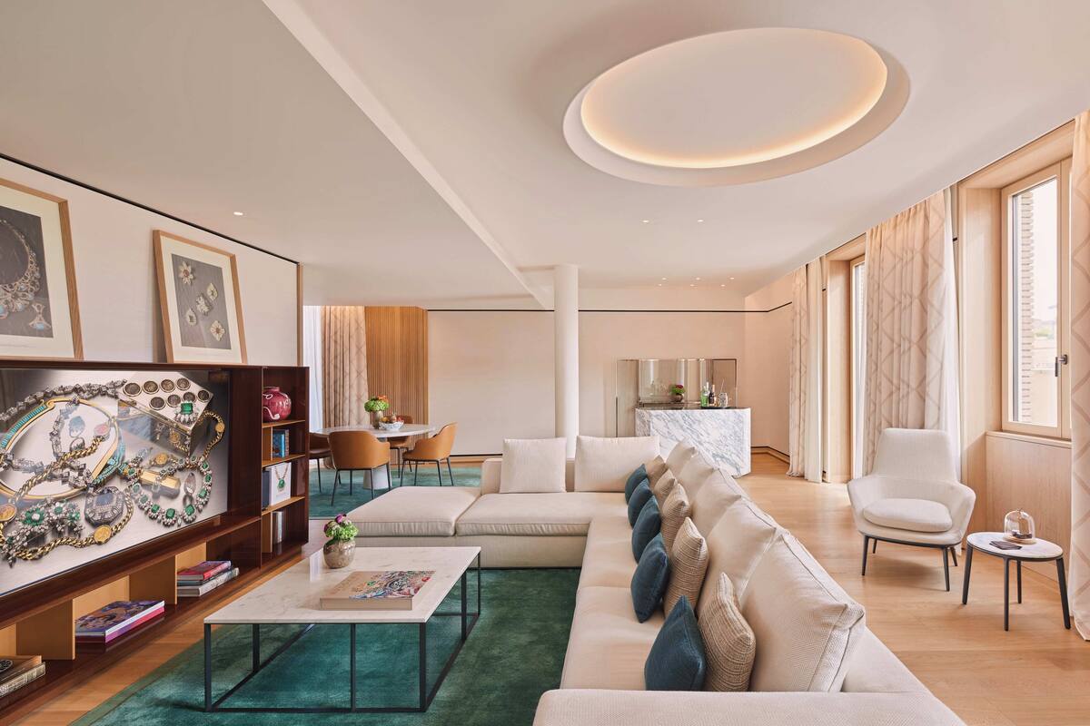 A modern living room with a sectional sofa, a coffee table, and a bookshelf.
