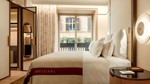 Ein Hotelzimmer mit einem großen Bett, einem Nachttisch, einem Spiegel und Blick auf den Balkon.