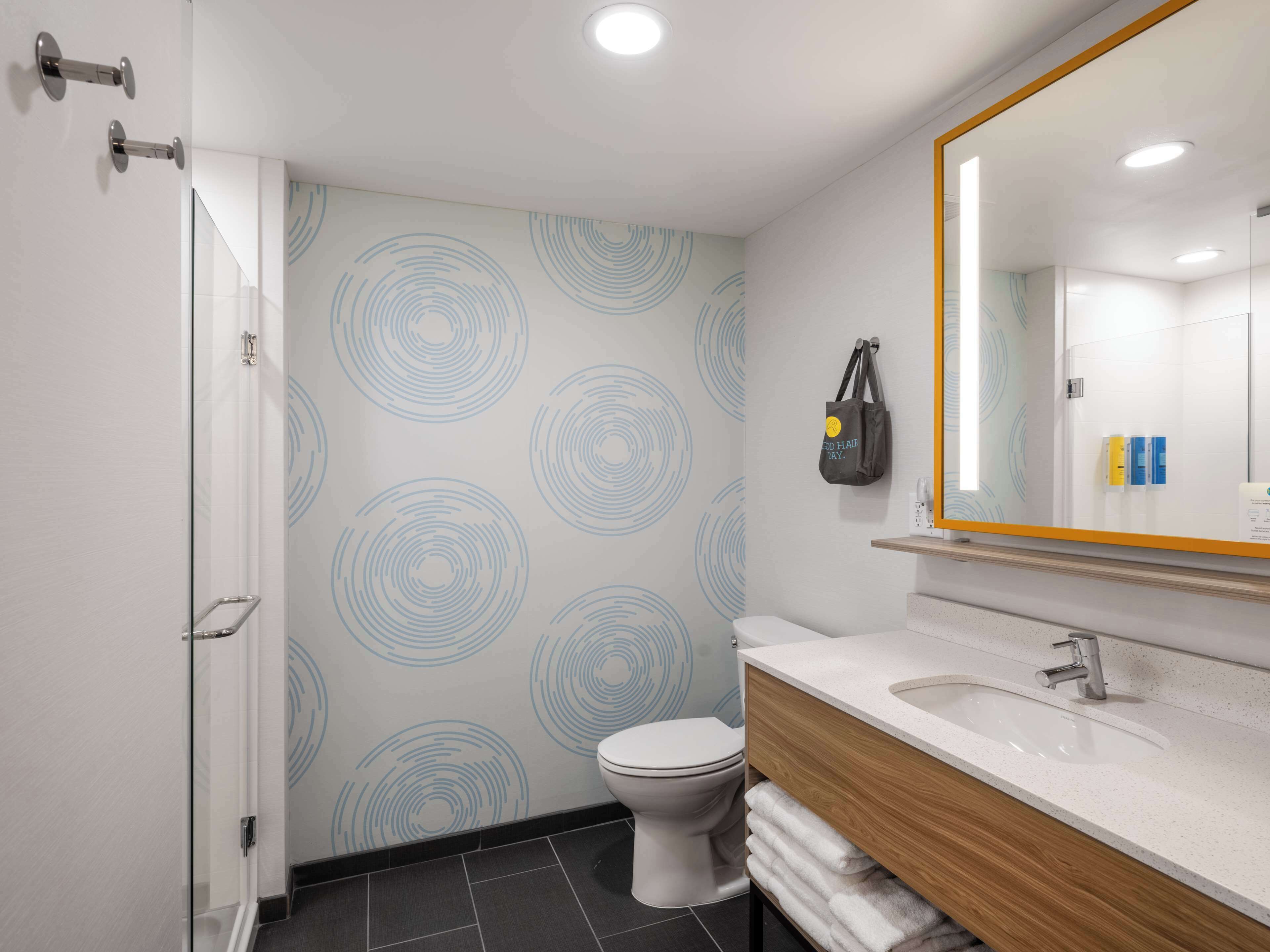 A modern bathroom with a toilet, sink, and glass shower enclosure.
