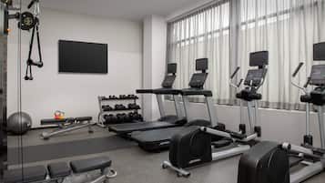 A gym with treadmills, elliptical machines, and weight benches.