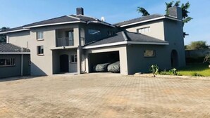 Une maison à deux étages avec une allée pavée et un garage.