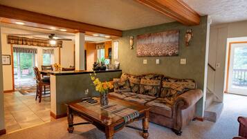 A cozy living room with a sofa, coffee table, and a painting on the wall.