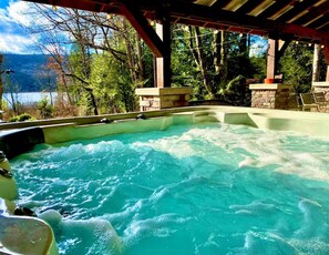 A hot tub with a view of a lake and forest.