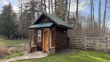 Een klein houten vakantiehuisje met schuine dak en een veranda.