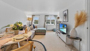 A modern living room with a dining area, a sofa, a TV, and a view of the outdoors. - Perfect Location, dog Friendly Beautiful Home (Whitstable)