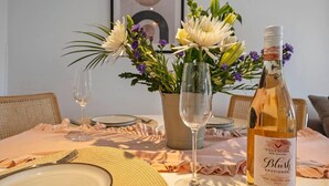 A dining table set with plates, cutlery, a wine bottle, and a vase of flowers. - Perfect Location, dog Friendly Beautiful Home (Whitstable)