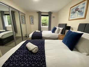 A hotel room with two beds, a large window, and a painting on the wall. - Pure Apartments Dunfermline East - Dalgety Bay (Saint Davids)