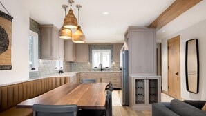 A modern kitchen with a wooden dining table, built-in cabinets, and pendant lighting. - Newly remodeled 4 bedroom condo only 1 block to Bridge St. & ski slopes, fre (Vail)