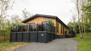 Ein Holzhaus mit Kiesweg und schwarzem Zaun.