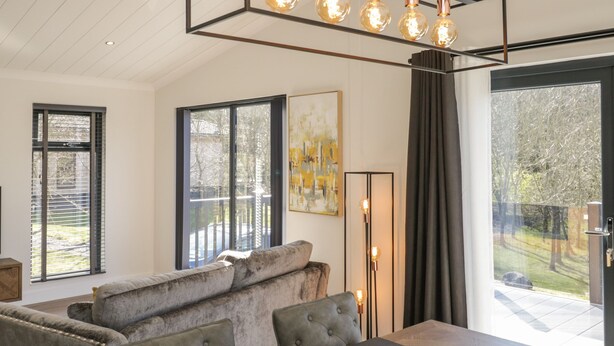 Ein modernes Wohnzimmer mit einer Couch, einem Esstisch und einem großen Fenster.