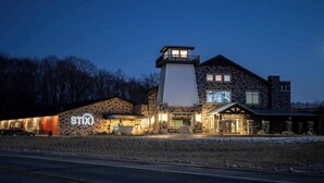 Ein Steinhaus mit einem markanten Turm und einem großen, hohen Fenster, vermutlich ein Hotel oder eine Lodge, mit einem Schild mit der Aufschrift "STIX".