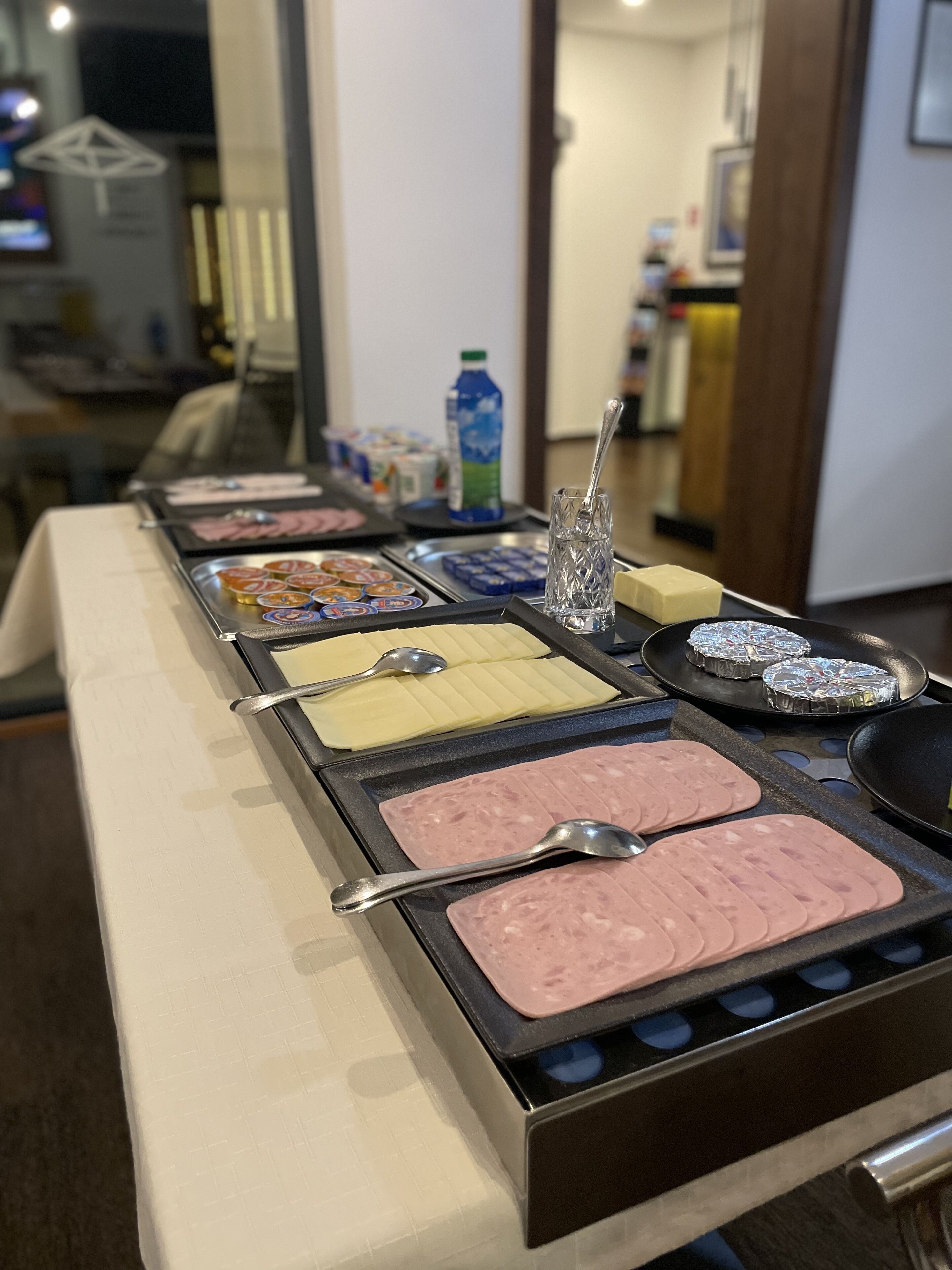 Un bufé con diversos alimentos, incluyendo diferentes tipos de carne y postres, dispuesto sobre una mesa.