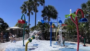 Ein Wasserspielbereich mit mehreren Wasserstrahlen und einem gefliesten Boden.