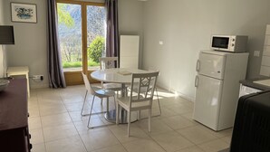 Una cocina moderna con una mesa de comedor, sillas, un refrigerador y un microondas.