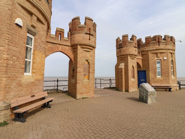 A historic brick building with a large archway and a small tower.