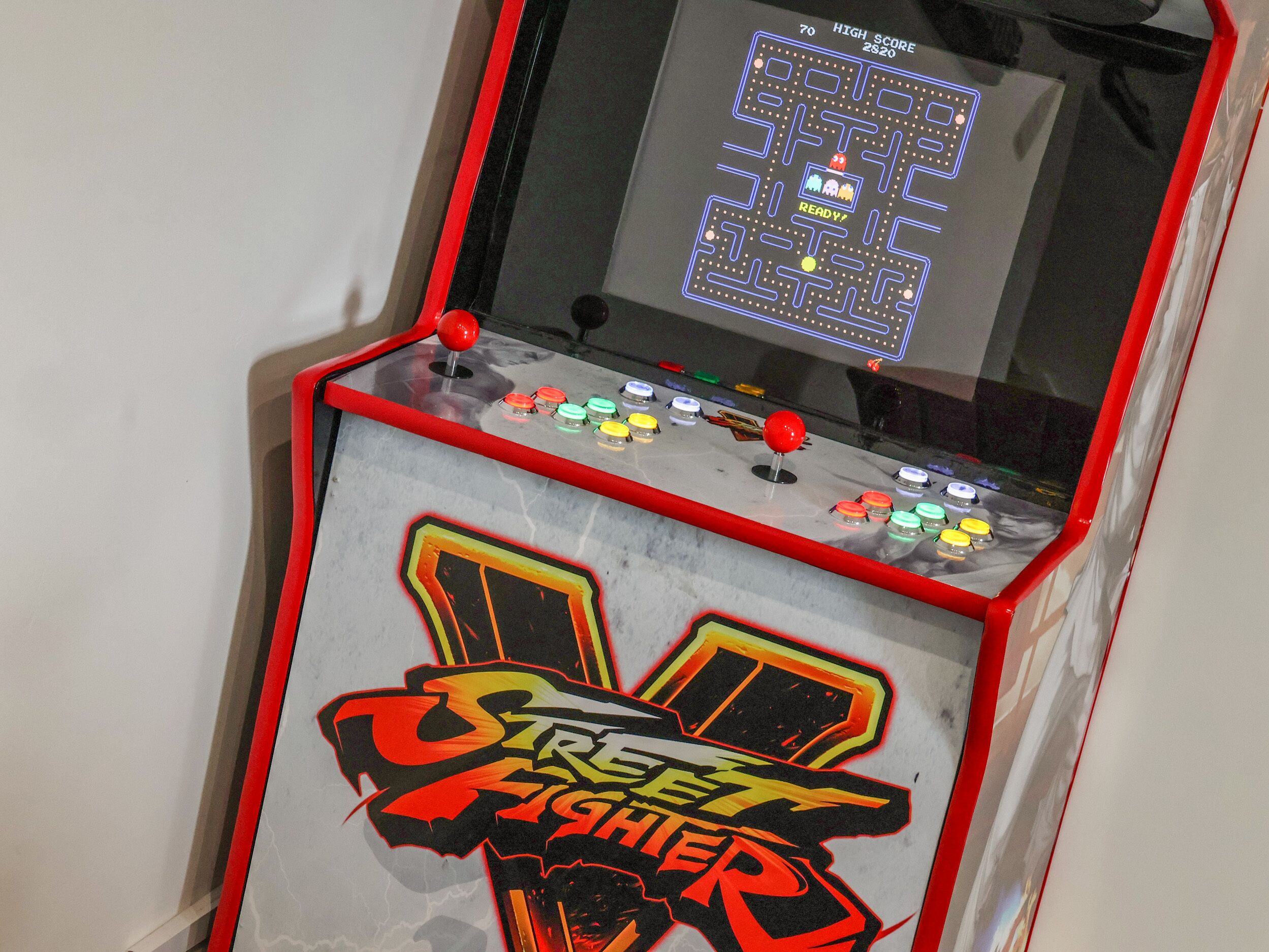 Eine Vintage-Spielautomatmaschine mit dem Schriftzug 'Street Fighter', ausgestattet mit einem Joystick und farbenfrohen Tasten.
