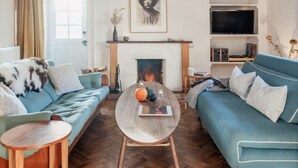 A living room with a sofa set, a coffee table, a fireplace, and a television. - Dell Cottage (Nethy Bridge)