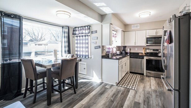 Una cucina moderna con zona pranzo, ampie finestre e vista sull'esterno.