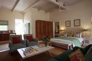 A spacious living room with a large bed, a dining area, and a kitchen. - Luxurious Country Lodge. (Stanford)