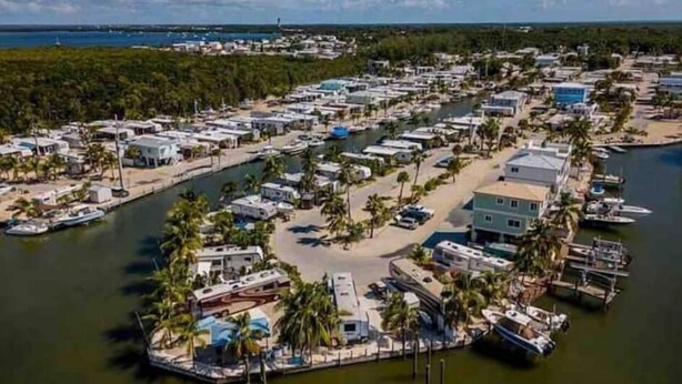 A marina with RVs and boats docked, surrounded by a residential area with houses and palm trees. - Key Largo 2 bedroom/1 bath with community pool (Key Largo)
