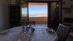 Une table à manger dressée pour quatre personnes, avec vue sur la plage.