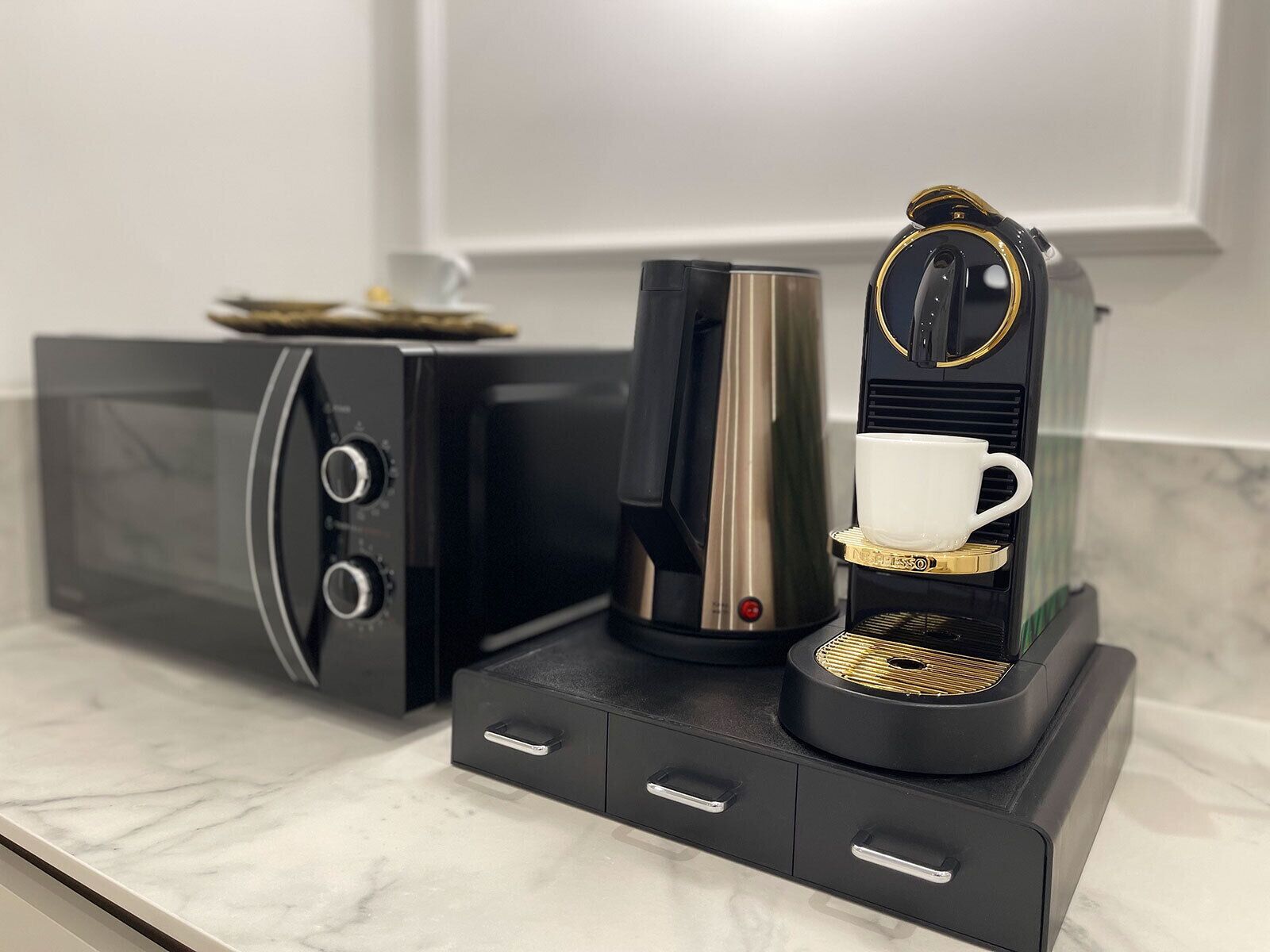A modern kitchen with a coffee machine, a microwave, and a coffee maker.