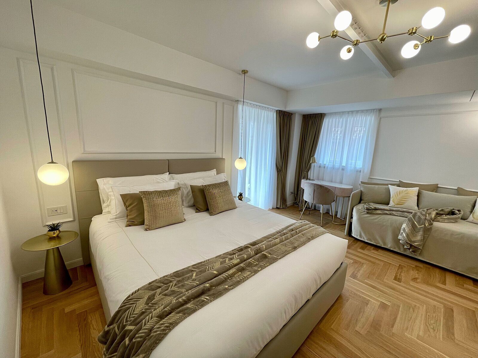 Una habitación de hotel moderna con una cama grande, un escritorio y un sofá.