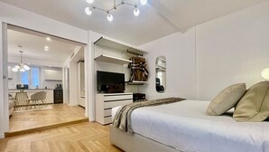 A modern bedroom with a large bed, a TV, and a wardrobe. - Bellagio Luxury Suites Apartments (Bellagio)