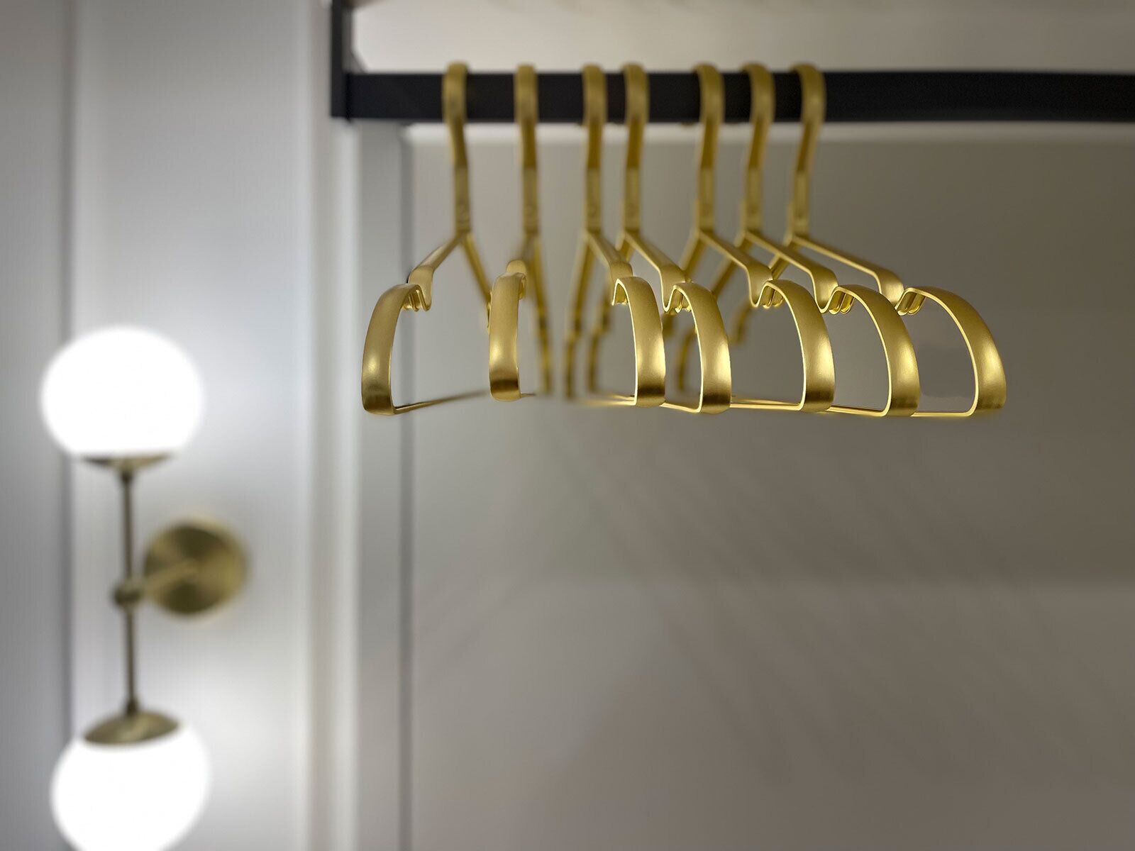 A gold-colored coat rack with multiple hooks in a modern interior setting.