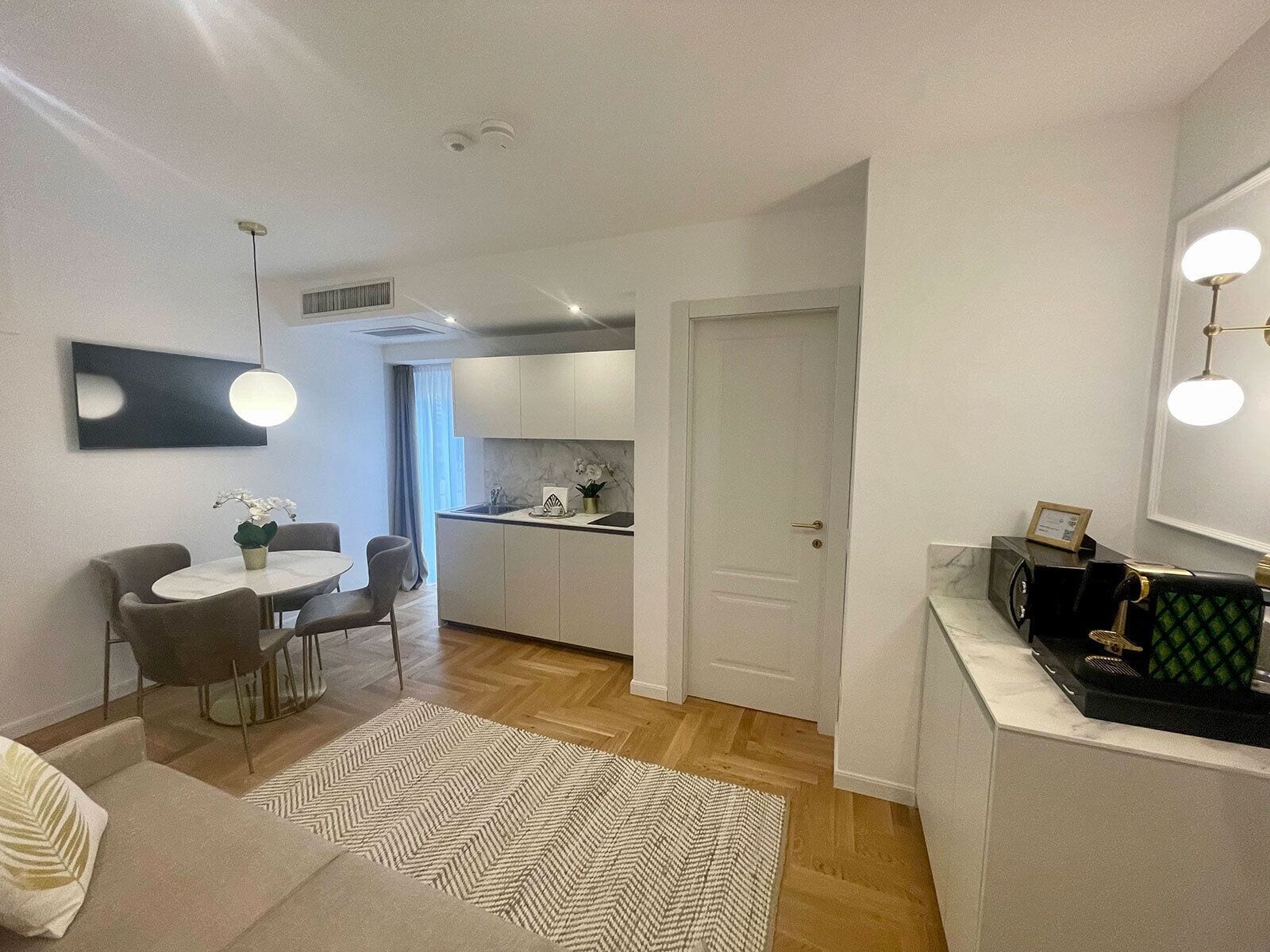 Un appartement moderne comprenant un coin repas, une cuisine et un espace de vie.