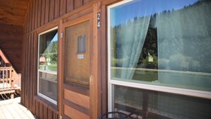 A wooden cabin with two large windows, a door with a number, and a small porch area. - Located on our Private Fishing Pond (Red River)