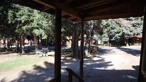 Un espacio al aire libre cubierto con un camino de grava, bancos y árboles.