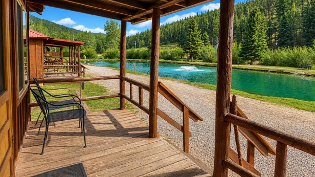 Eine Holzterrasse mit Blick auf einen See und einen Wald.