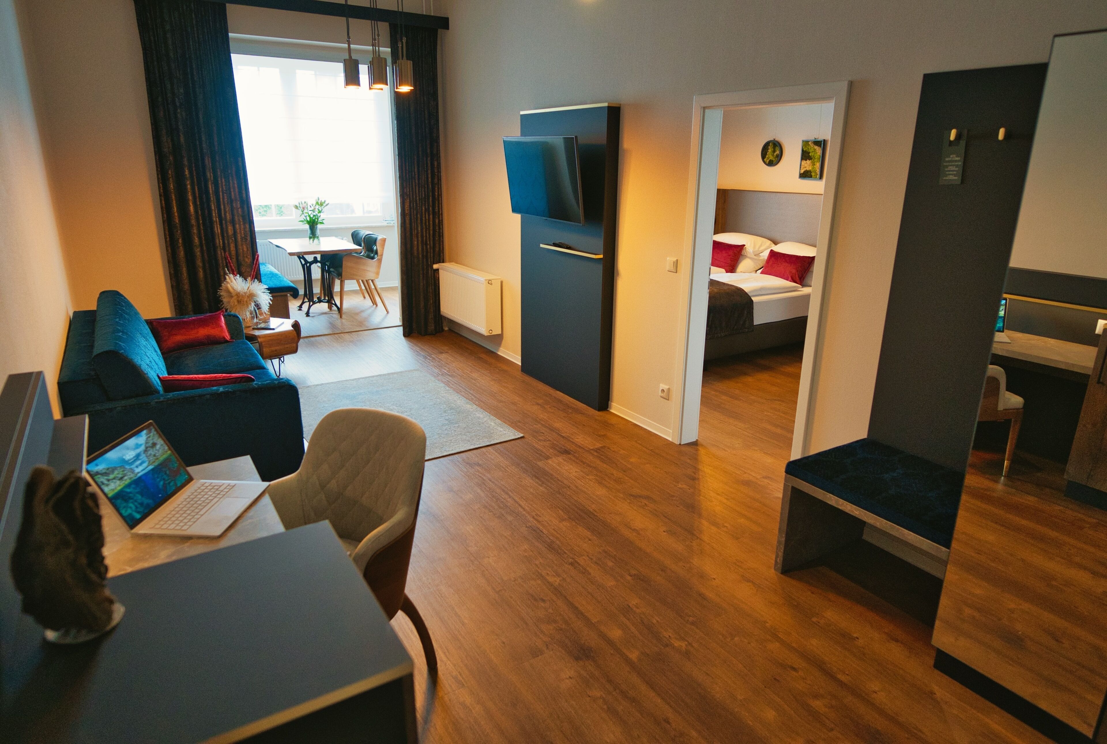 Una habitación de hotel moderna con sala de estar, comedor, dormitorio y kitchenette.