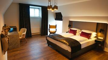 A modern hotel room with a large bed, a desk, and a chair.