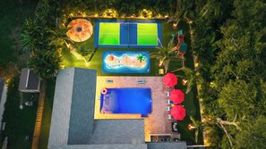 Een zwembad op het dak met een tennisbaan, een jacuzzi en een klein zwembad.