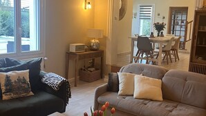 A cozy living room with a sofa, a coffee table, and a dining area in the background. - Provencal house with heated pool and garden - sleeps 6 (Saint-Didier)