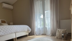 A bedroom with a bed, a fluffy rug, a radiator, and a window with sheer curtains. - Provencal house with heated pool and garden - sleeps 6 (Saint-Didier)