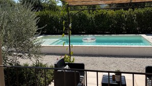 A covered outdoor area with a pool, seating, and a pergola. - Provencal house with heated pool and garden - sleeps 6 (Saint-Didier)
