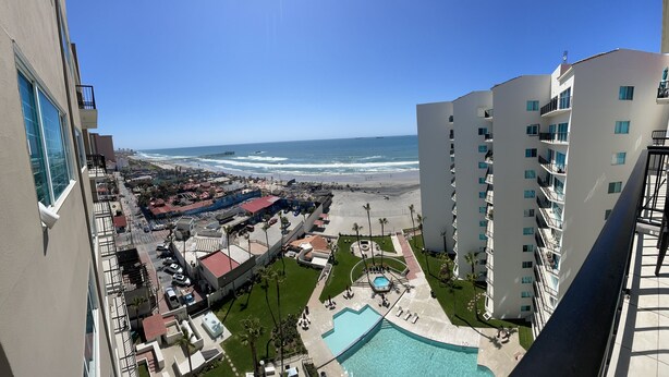 A high-rise building with a view of a beach and a swimming pool. - Beachfront Penthouse in downtown Rosarito Beach (Rosarito)