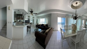 A spacious living area with a central island, a dining table with chairs, a sofa, and a ceiling fan. - Beachfront Penthouse in downtown Rosarito Beach (Rosarito)