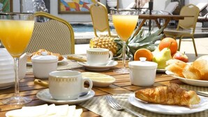 Impostazione per la colazione con tavolo, sedie e vista sulla piscina.