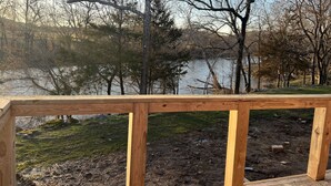 Eine Holzterrasse mit Blick auf einen See und Bäume.